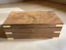 A mahogany and brass campaign writing slope, width 46 cm, fitted with a secret drawer with key.