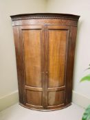 A George III inlaid mahogany bow front hanging corner cabinet,