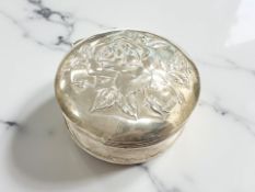 An Edwardian embossed silver ring box depicting a rose, Chester 1909, diameter 6.