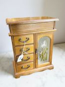 A mahogany effect four drawer jewellery box, with mirrored panel back and lift up lid, width 26 cm.