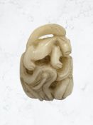 An antique Chinese pale jade carving depicting a squirrel on a branch with nut,