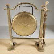 A brass dinner gong with beater, height 27 cm.