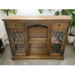 An Old Charm carved oak bookcase with leaded glass doors, 123 cm x 29 cm x 100 cm.