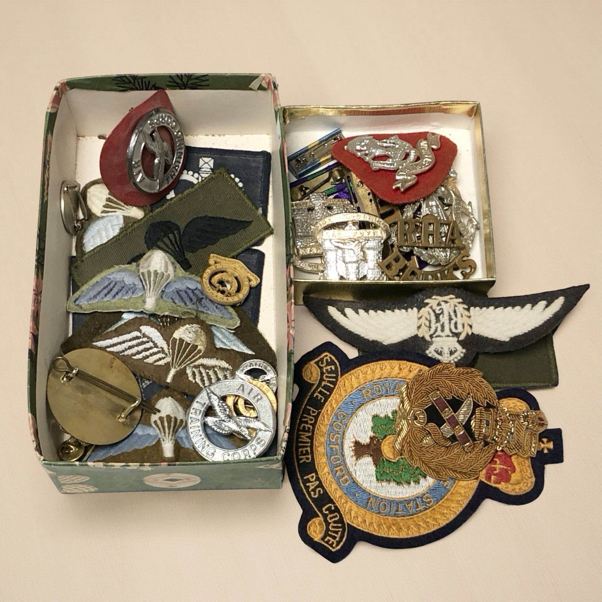 A quantity of military cloth insignia and various badges, cap badges, including RAF.