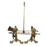 A pair of brass fire dogs and a three piece companion set.