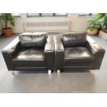 A pair of Scandinavian black leather lounge armchairs on chrome feet,