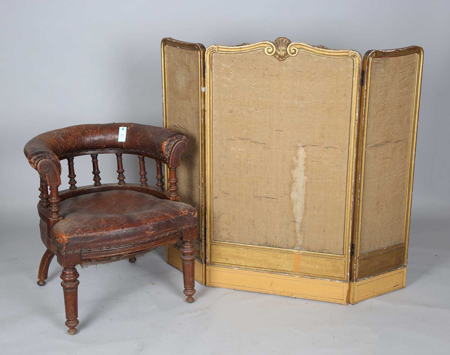 A late Victorian oak framed tub back desk chair, upholstered in brown leather, height 74cm, width
