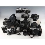 A collection of Canon, Minolta and Olympus 35mm cameras, including OM-1 with 50mm lens, OM-2 with