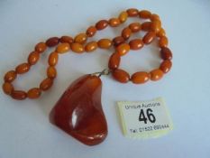 An amber necklace with pendant attachment. 57.48 grams.