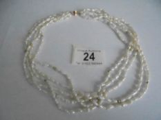A superb three strand natural pearl necklace with 14k gold clasp.