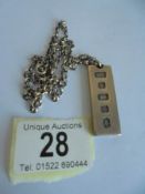 A heavy silver ingot on a silver chain.