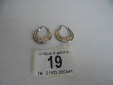 A pair of 9ct gold hoop earrings engraved with flowers and foliage, 1.2 grams.