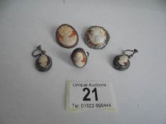 Two shell cameo brooches in silver mounts, a pair of white metal cameo earrings and a cameo ring.