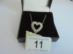 A yellow gold and diamond heart on a 9ct gold chain, 4 grams.