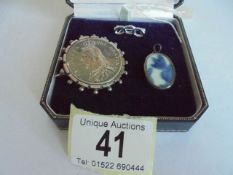 An 1887 Victorian silver coin as a brooch, another brooch and a pendant.