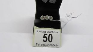 An 18ct three stone diamond ring, size Q. 5.41 grams.