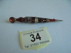 A white metal and stone set Celtic kilt pin.