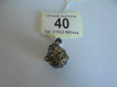 A Faberge' style egg pendant containing a Teddy bear.