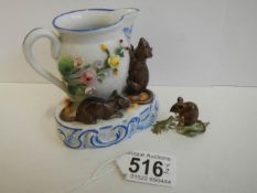 A porcelain cream jug surmounted mice and another mouse figure.