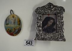 An un-marked silver framed religious print and a metal oval miniature religious plaque.