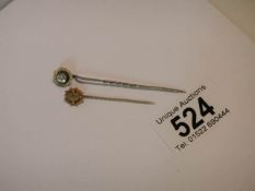 Two yellow metal stick pins.