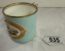 A 19th century hand painted coffee can with countryside scene in a gilded oval, signed to base G H