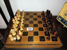 A vintage wooden chess set with folding board box