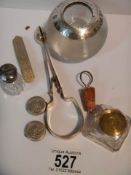 A mixed lot including silver topped match striker, silver top bottle, inkwell, EPNS sugar tongs etc.