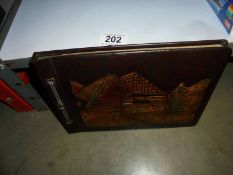 A vintage worked leather postcard/photo album.