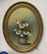 An oval gilt framed oil on board still life of flowers signed J. Cooper
