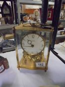 A brass anniversary clock in the style of a carriage clock.