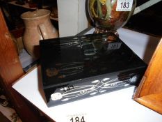 A Renee Macintosh style jewellery box including an art deco brooch and two others.