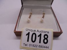 A pair of pendant drop earrings in 9ct gold with pearls to edges.