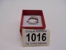 An 18ct white gold and platinum three stone diamond ring, size K half, 3.23 grams.