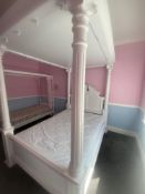 A wood-framed four-poster double bed