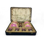 A cased set of pink and gilt Aynsley coffee cans and saucers with silver can holders