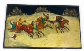 A 20th century Russian polychrome painted lacquer panel of figures in horse drawn sleighs in the sno