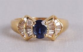 Een 18 krt geelgouden ring, bezet met blauwe gefacetteerde saffier en diamant.