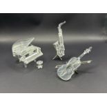Three unboxed Swarovski crystal musical instruments including Chello, Saxophone and Piano with stool