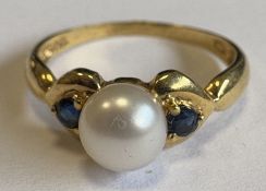 A 9 carat sapphire and pearl three-stone ring.