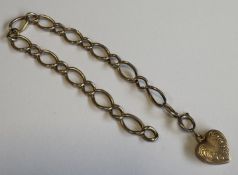 A 9 carat curb link bracelet with heart-shaped pendant.