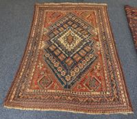 A large oriental rug decorated in bright colours on red ground.