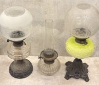 An etched-glass oil lamp together with two others.
