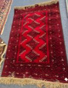 An old rug decorated in red ground. Est. £30 - £50