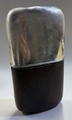A large silver, glass and leather flask.