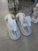 Large pair of concrete dogs laying down