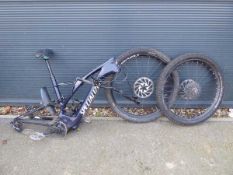 Dark blue specialised carbon fibre framed mountain bike. Two wheels and handlebars are disconnected