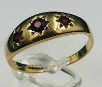 A 9ct yellow gold ring with three star garnets, approximate weight 2.1g and size P