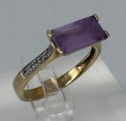 A 9ct gold fashion ring with purple stone and diamond shoulders, approximate weight 2.7g and size Q