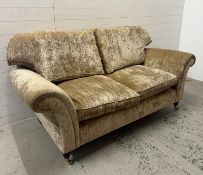 A two seater fawn upholstered sofa
